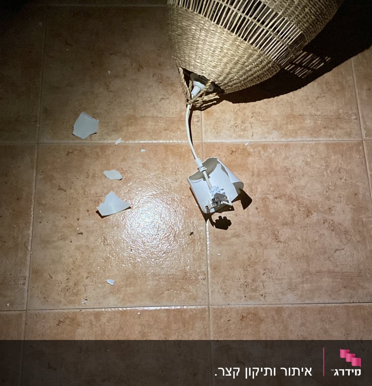 מנורה שבורה על הרצפה עם חוט חשמל